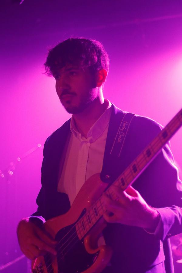 Musicien jouant de la basse sous une lumière magenta