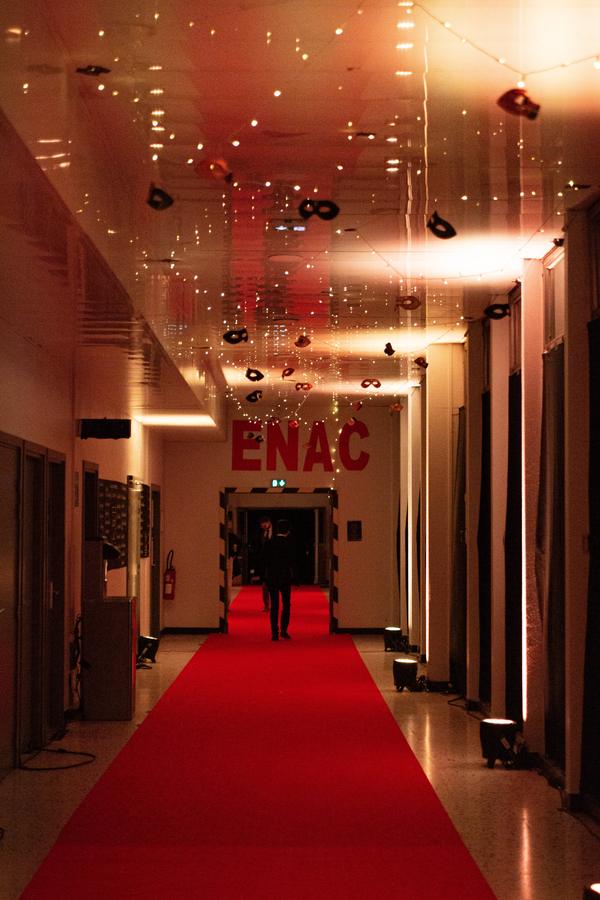 Allée au tapis rouge sous une guirlande lumineuse, enseigne ENAC au fond