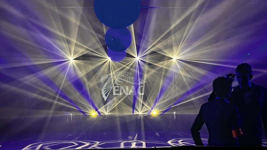 Faisceaux lumineux croisés au-dessus de la scène, logo ENAC projeté